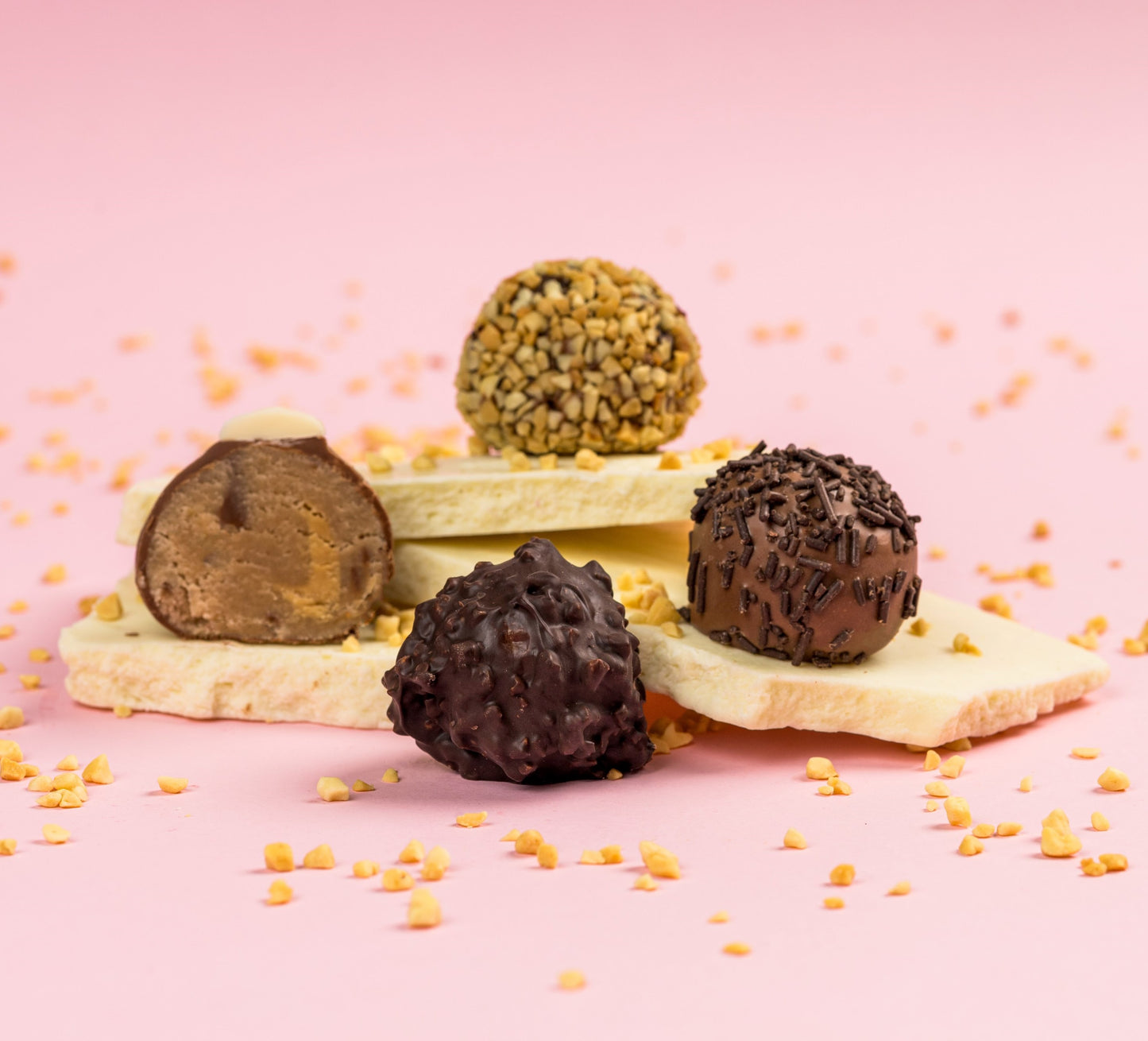 Négy féle marcipán kompozícióban, csokoládé táblán topping szórással. Four types of marzipan in a composition, with chocolate bars and sprinkled toppings. Vier Arten von Marzipan in einer Komposition, mit Schokoladentafeln und bestreuten Toppings.