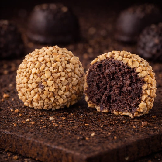 Kakaós keksz alap egy csepp rum aromával és gyümölcs lekvárral gazdagítva, tört mogyoródarabkákkal bevonva.